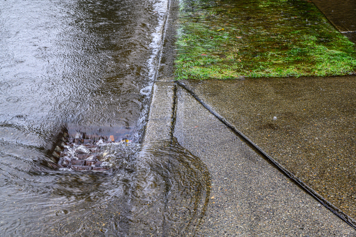 Heavy rain caused flooding in street water swirling around storm drain - Central Indiana Land Trust